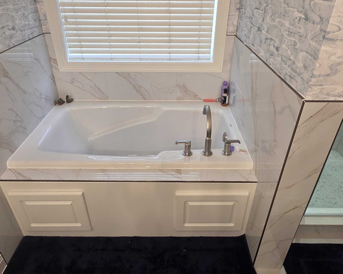 Tiled tub deck and glass shower in a finished bathroom