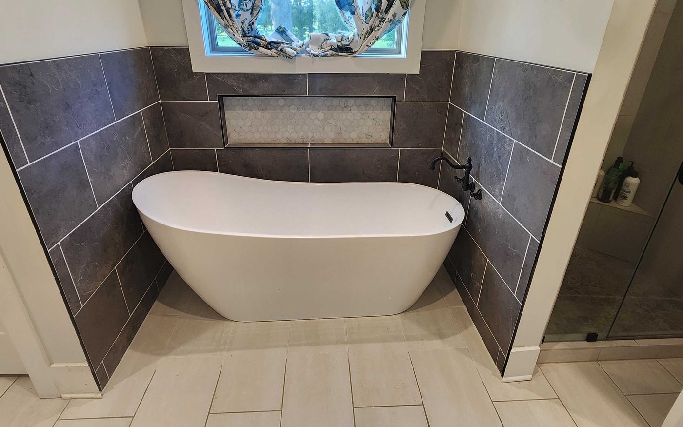 Finished bathroom with a freestanding tub and a subway tile shower
