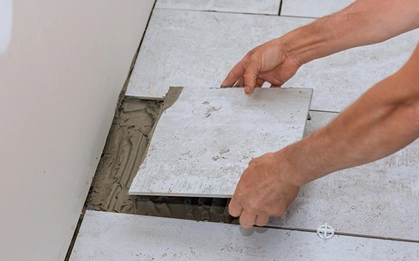 Setting a new floor tile into thinset during a tile repair